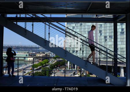 Visitors on staircase of outdoor terrace of Whitney Museum of America Art with the Standard Hotel in Meatpacking district in background.New York City. Stock Photo