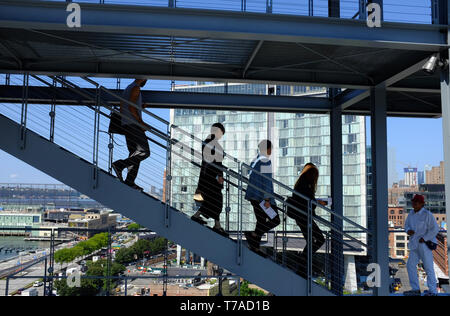 Visitors on staircase of outdoor terrace of Whitney Museum of America Art with the Standard Hotel in Meatpacking district in background.New York City. Stock Photo