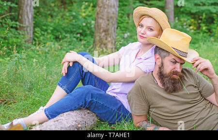 Reasons you should definitely wear more hats. Hats for tourism. Choose proper clothing and equipment to hike and forest picnic. Couple tourists wearing hats. Couple in straw hats sit meadow relaxing. Stock Photo