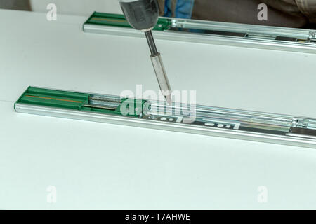 Assembling furniture from chipboard, using a cordless screwdriver, close up Stock Photo