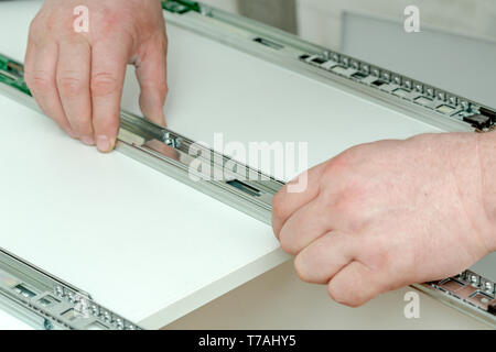 Assembling furniture from chipboard, using a cordless screwdriver, close up Stock Photo