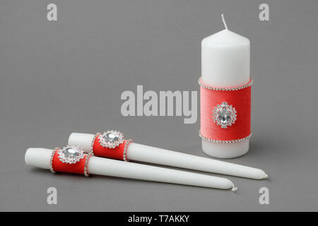 Beautiful candles decorated with coral velvet cloth. Stock Photo