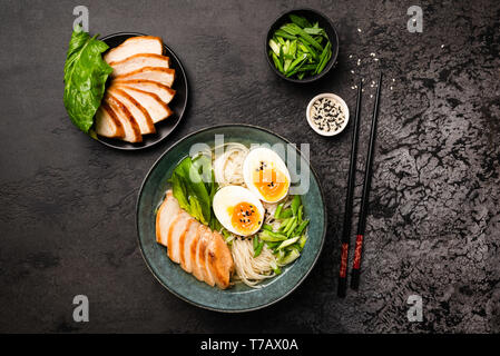 Asian Chicken Ramen Noodle Soup On Black Concrete Background. Table Top View Stock Photo