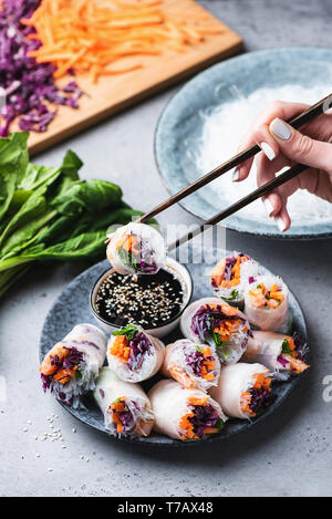 Rice paper rolls or spring rolls with teriyaki based dipping sauce, asian cuisine. Eating spring rolls Stock Photo