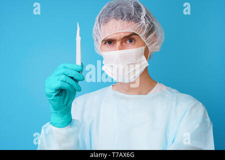 Surgeon in sterile blue uniform, medical gloves and mask Stock Photo