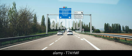 France - Apr 19, 2019: Light traffic on French highway perspective view at the long autoroute and St Die des Vosges, Schirmeck, Molsheim, Colmar, Mulhouse, Duppigheim, Duttlenheim arrow direction signs Stock Photo