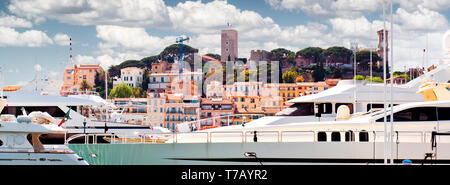 Cropped image cloudy bright sunny sky luxury rich yachts moored at Port Le Vieux view to the Le Suquet old town view of Cannes, France Stock Photo