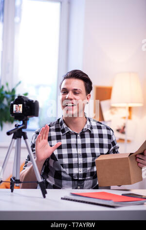 Expressive dark-haired man being involved in recording video Stock Photo