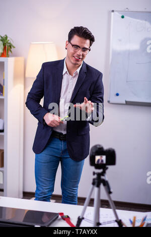 Self-confident handsome man in elegant outfit working on camera Stock Photo