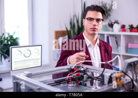 Serious man in clear glasses wearing dark red jacket and white shirt Stock Photo