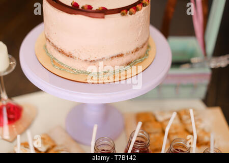 Tasty sweet pink creamy cake and drinks on table. Stock Photo