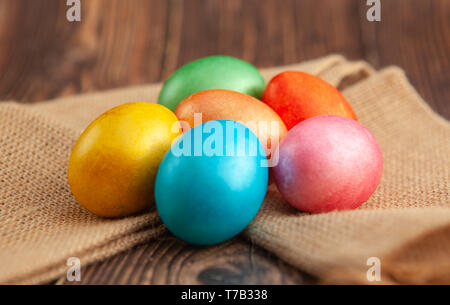 Colored Easter eggs on a wooden background on burlap Stock Photo