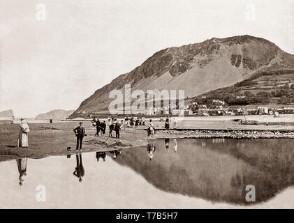 A late 19th Century view of of people on the beach that fronts Llanfairfechan, a town in the Conwy County Borough, Wales.Behind is Penmaenmawr Mountain. Stock Photo
