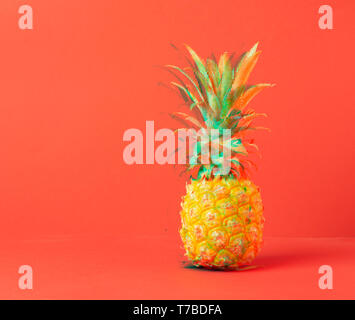 Yellow ripe pineapple on a red background. Concept minimalism. Glitch effect processing. Copy space. Horizontal Stock Photo