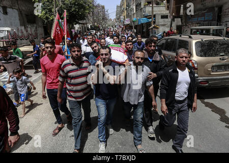 Beit Lahia, Palestinian Territories. 06th May, 2019. Mourners carry the body of a Palestinian man who was allegedly killed during Israeli airstrikes on Beit Lahia. Following the most severe escalation of violence between Palestinians and Israelis since the 2014 Gaza War, Hamas indicated on Sunday that the group, which rules the Gaza Strip, was prepared to arrange a new ceasefire with Israel. Credit: Mohammed Talatene/dpa/Alamy Live News Stock Photo