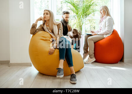 Young couple having misunderstandings during the psychological counseling with senior female psychologist in the office Stock Photo
