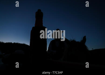 Riding horse. Silhouette of a cowboy with hat against light just before sunset with the sky blue intense, during rodeo in the ejido Cuquiarachi. Stock Photo