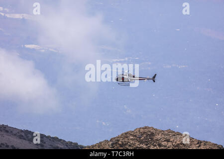 Helicopter with tourists flying high in the blue sky, good sunny day without clouds, can see all beautiful nature landscapes from the top. Stock Photo