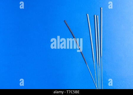 Burning sparklers on blue background and copy space. Bengal fire sparkles Stock Photo