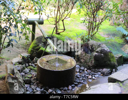 A unique ancient wash-basin of stone Tsukubai in Ryoanji Temple, Kyoto, Japan. UNESCO world heritage site Stock Photo