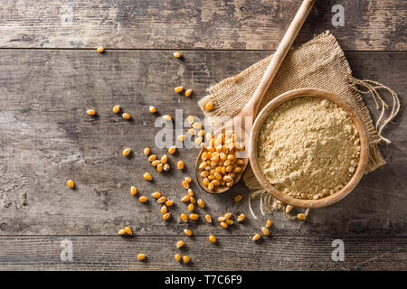 Corn flour in bowl on wooden table Stock Photo