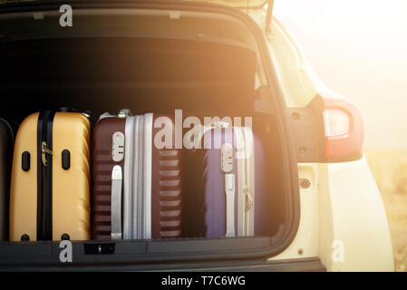 Opened car trunk full of suitcases in sunlight effect. Travel, adventure concept. Packed baggages for summer holidays Stock Photo