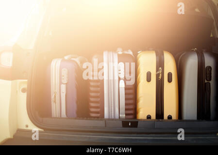 Opened car trunk full of suitcases in sunlight effect. Travel, adventure concept. Packed baggages for summer holidays Stock Photo