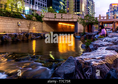 a couple sits on the edge of the stream, Seoul,South Korea Stock Photo