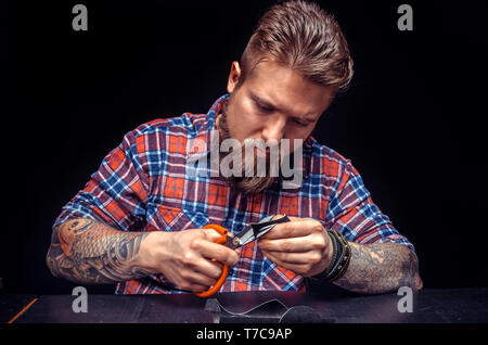 Artisan cutting leather outlines for his new production Stock Photo