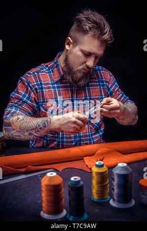 Professional Leather Worker forms new leather product at his workshelf Stock Photo