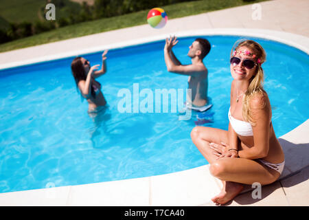 Friends playing ball games in pool Stock Photo