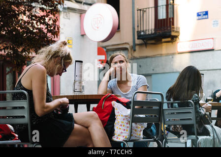 Madrid, Spain - April 14, 2019: Unidentified couple of tourists enjoying sitting at sidewalk cafe in the Quarter of Letters in the old Madrid Stock Photo