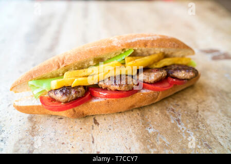 Homemade tasty and delicious spicy meatball in the sandwich with tomato, fried potatoes and green pepper. traditional turkish kebab Stock Photo