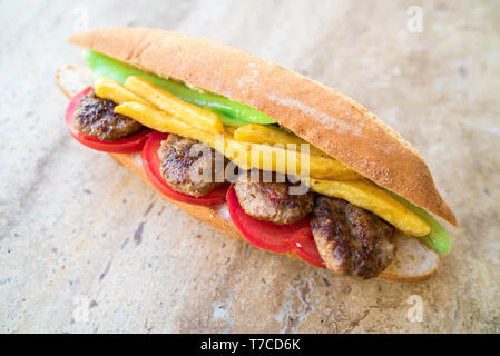 Homemade tasty and delicious spicy meatball in the sandwich with tomato, fried potatoes and green pepper. traditional turkish kebab Stock Photo