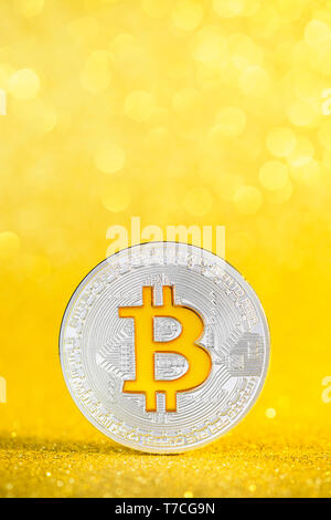 Bitcoin coin with golden bitcoin symbol on golden glitter bokeh background Stock Photo