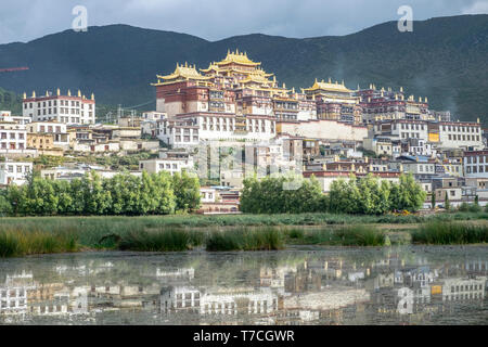 Songzanlin Tibetan Buddhist Monastery reflected in sacred lake, Shangri-La, Yunnan Province, China Stock Photo