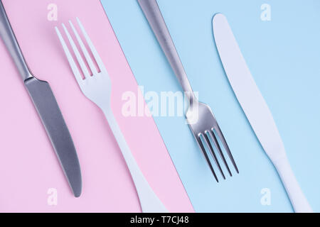 Knife and fork set on trendy soft pastel color paper background Stock Photo