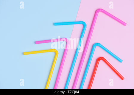 Colorful plastic drinking coocktail straws on pink and blue trendy pastel background Stock Photo