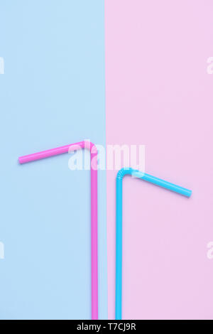 Pink and blue pastel colored drinking cocktail straws on double colored trendy paper background Stock Photo