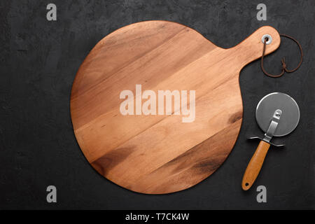 Pizza cutting board with pizza knife on dark rustic background Stock Photo