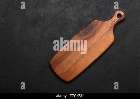 Wooden cutting board, clean and new, on dark rustic background Stock Photo