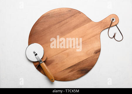 Pizza cutting board with pizza knife on white rustic background flat lay top view Stock Photo