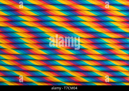 Rainbow vibrant multicolored striped paper straws background Stock Photo