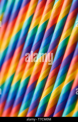 Rainbow multicolored paper cocktails straws in row abstract background Stock Photo