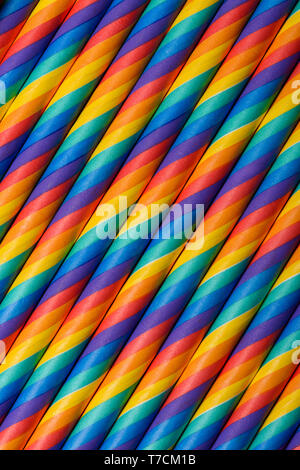 Rainbow vibrant multicolored striped paper straws vertical background Stock Photo