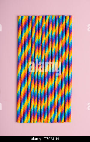 Rainbow paper cocktail straws on pink pastel background Stock Photo