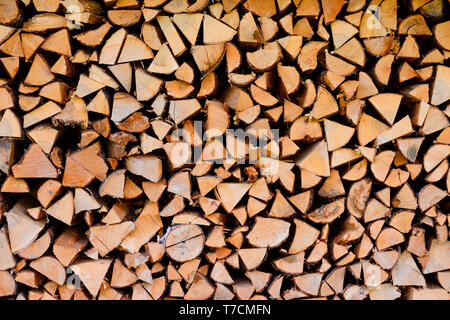 Wood logs firewood big chopped trunks stacked pile dry for winter fireplace texture background Stock Photo