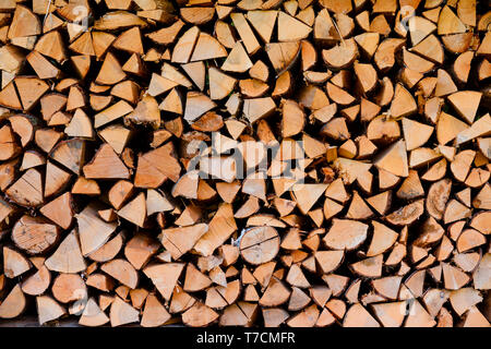 Firewood wooden logs big chopped trunks stacked pile dry for winter fireplace texture background Stock Photo