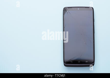 Broken smartphone screen. Glass phone touch screen cracked after drop, top view with copy space Stock Photo