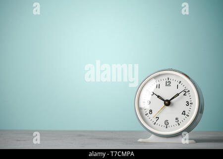 Retro old classic round alarm clock on desk blue vintage color background with copy space Stock Photo